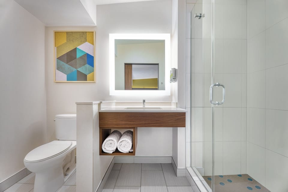 Refresh in a spotless bath with bright vanity lighting.