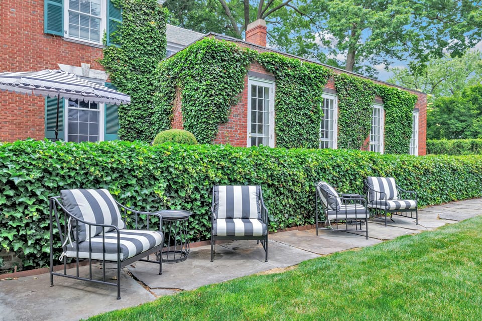 Lined with ivy-covered walls and lush greenery, this charming seating area offers a peaceful spot to relax outdoors. Perfect for sipping a drink, reading a book, or enjoying the garden views.
