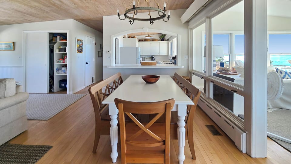 Dining area with large table and kitchen beyond