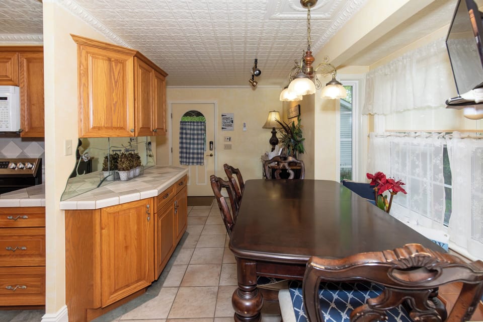 Gather around this warm, sunlit dining space where mornings begin with coffee and evenings bring laughter. The classic wood table invites your group to share meals, plan adventures, or simply enjoy great company.