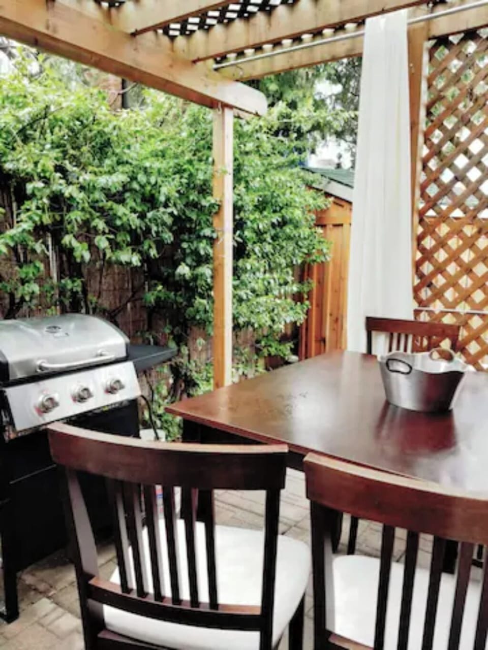 Outdoor covered patio with seating and barbecue