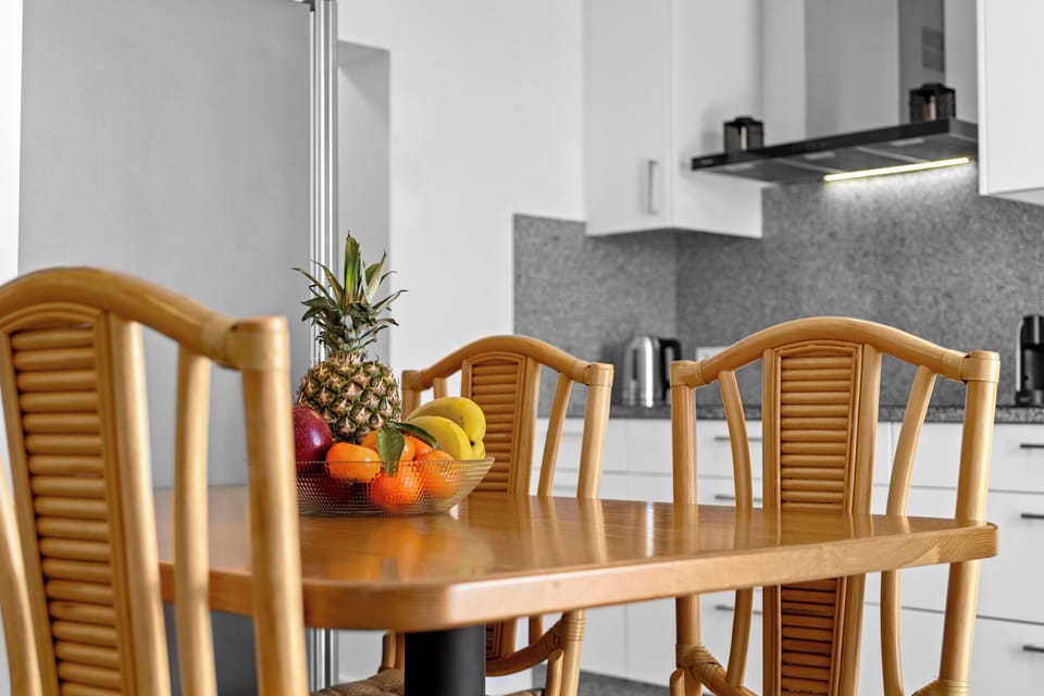 fully equipped kitchen, a comfortable living area, and a dining table