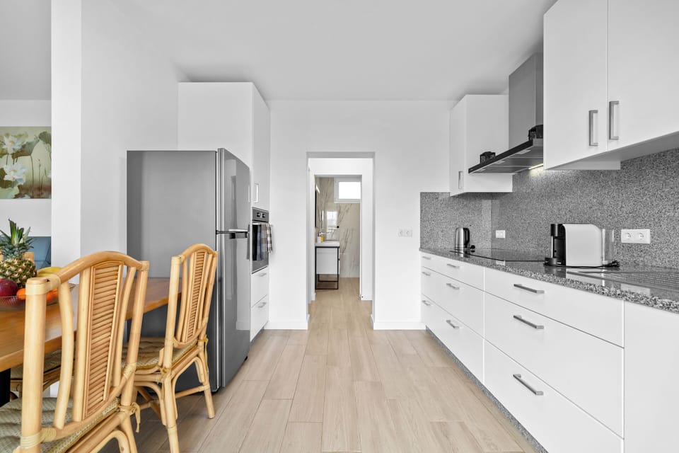 fully equipped kitchen, a comfortable living area, and a dining table