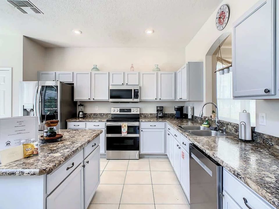 Modern kitchen with stainless steel appliances, granite countertops, and plenty of cabinet space—perfect for cooking meals during your stay.