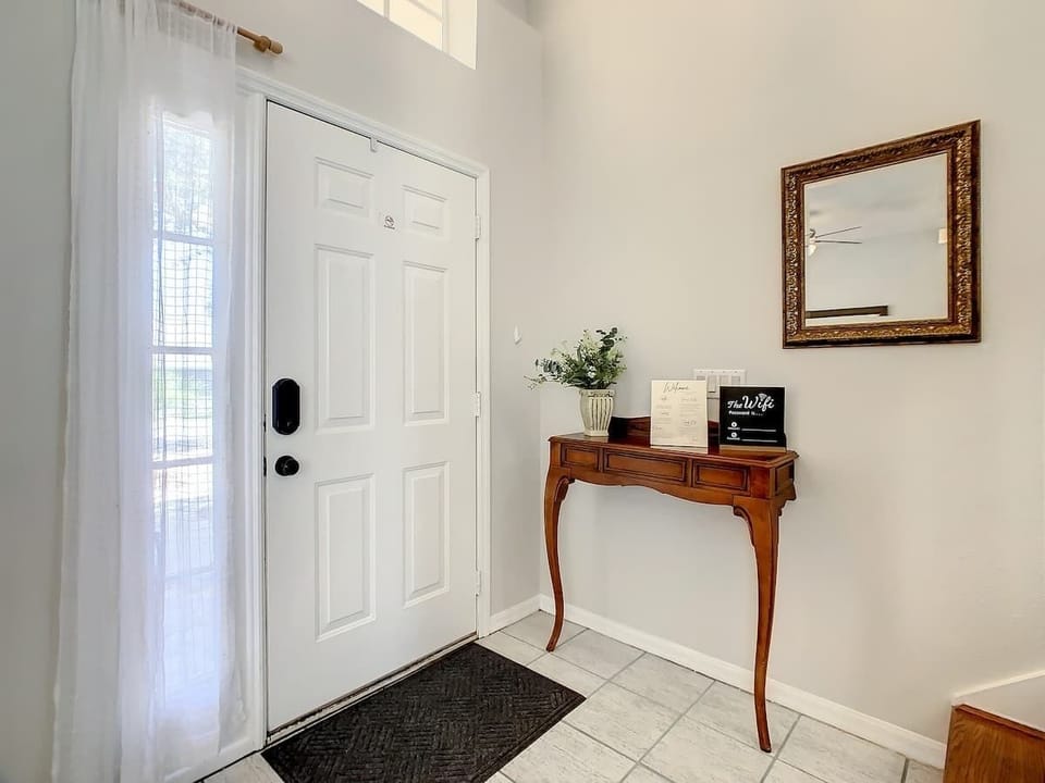 Bright and welcoming entryway with high ceilings, natural light, and a stylish console table, setting the tone for your relaxing stay.