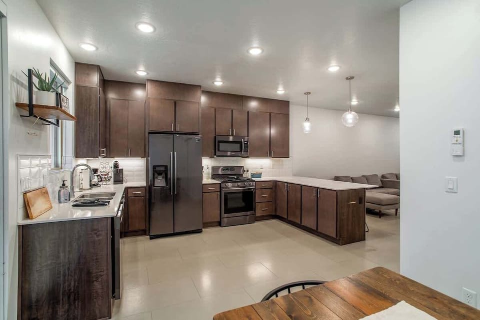 View from the dining space showcasing the expansive kitchen layout, sleek countertops, and contemporary finishes for a stylish stay.