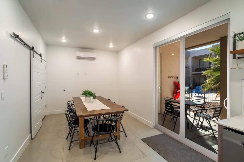 Spacious dining area with seating for eight, conveniently located near the back patio for seamless indoor-outdoor dining. The barn-door style pantry contains pickleballs and paddles, pool towels, and other various items for your enjoyment.