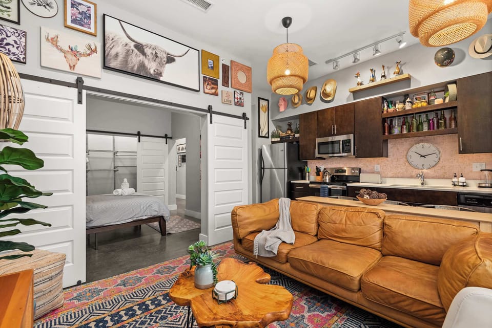 Open-concept living room with barn-door bedroom entry and kitchen bar