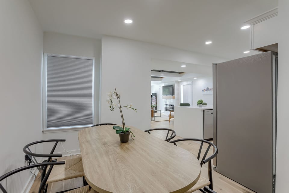 This dining room is perfect for family dinners or hanging out with friends. It's got a nice, chill vibe with the white walls and lots of light.