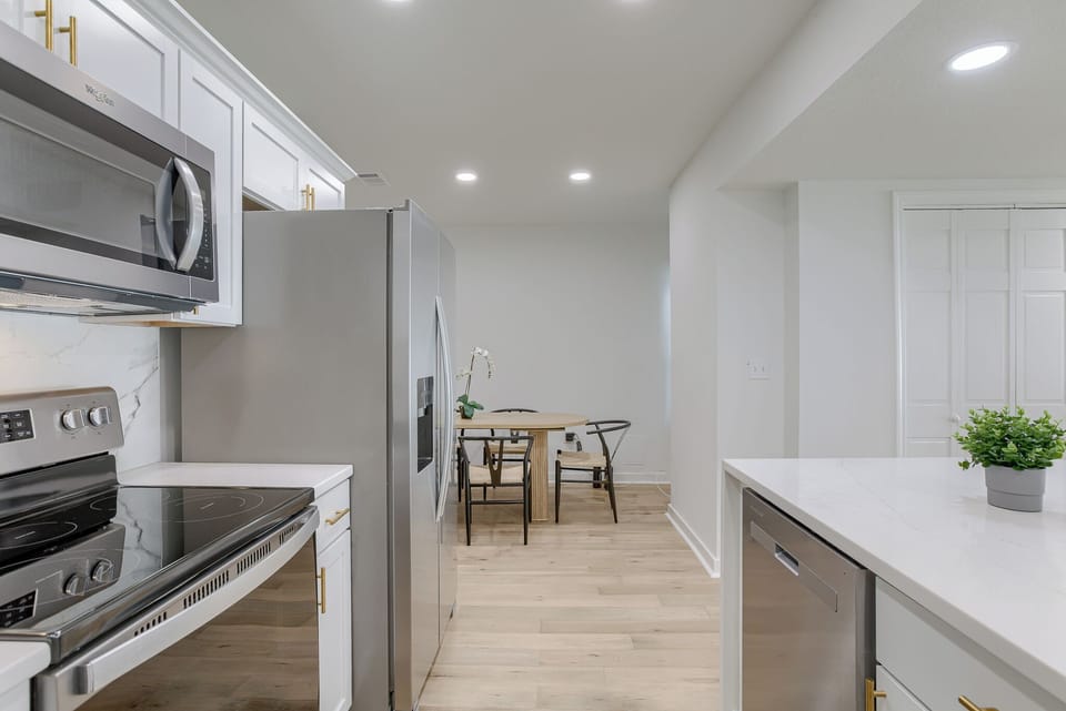The open layout connects to the living room, so it's perfect for hanging out and cooking.  It's got everything you need, including a coffee maker, so you can whip up your favorite meals and drinks.