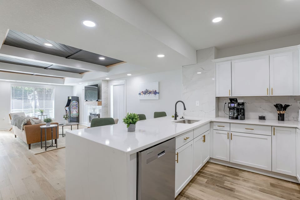 A breakfast bar with bar stools provides a casual dining option. The open layout allows for easy interaction with the living area, making it perfect for entertaining guests.