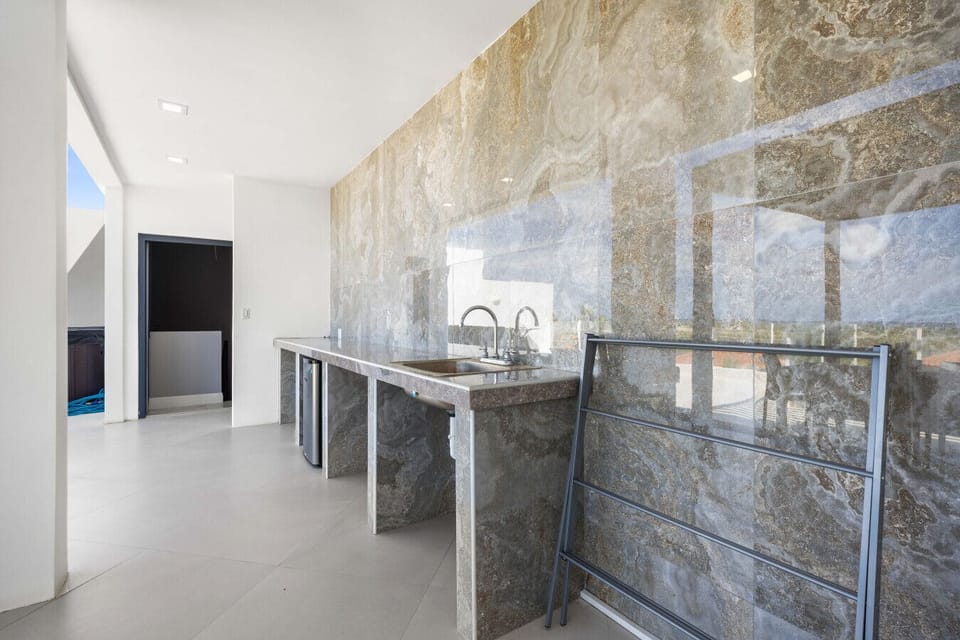 Prep and serve meals with ease at the outdoor kitchen—complete with sink, counter space, and a mini fridge, perfect for BBQ days and sunset drinks on the terrace.