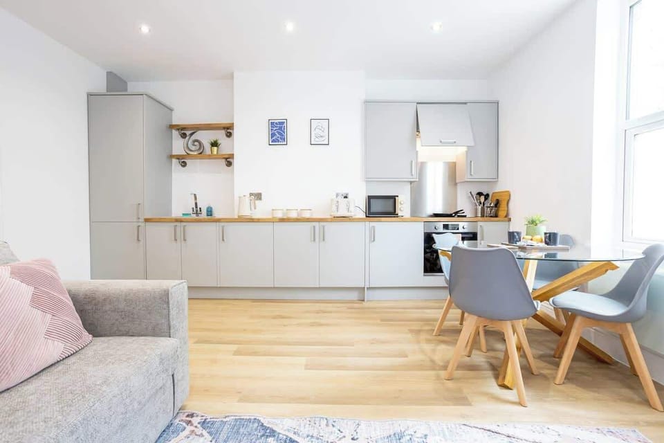 The open-plan living space benefits from a double sofa-bed, a 4-seater dining table and a fully equipped kitchen with everything you need for a short or long-term stay in Manchester.