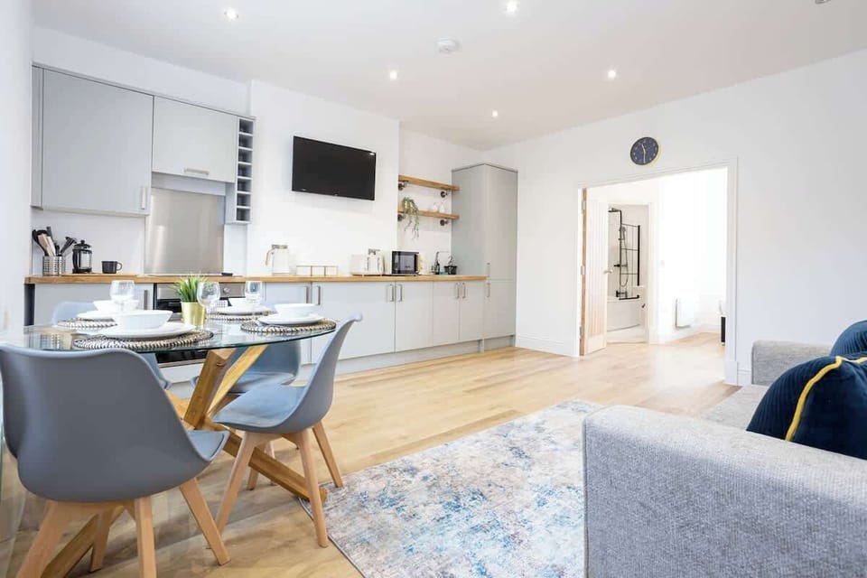 The open-plan living space benefits from a double sofa-bed, a 4-seater dining table and a fully equipped kitchen with everything you need for a short or long-term stay in Manchester.