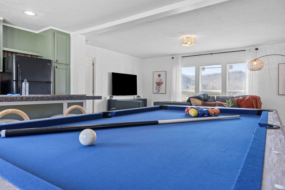 Perfect your pool game on this vibrant blue table, a fun addition to the spacious living area.
