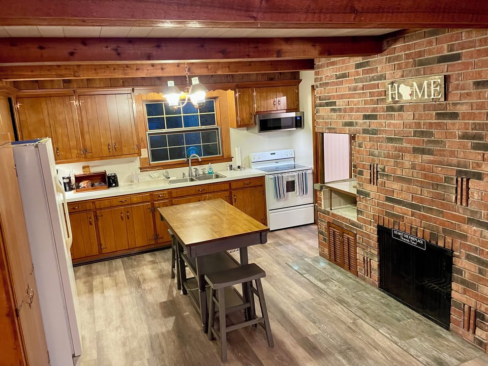 The wood beam ceiling of this kitchen perfectly matches the forest setting.
