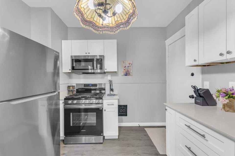 Clean kitchen w/ stainless stove, bright cabinetry & simple modern finishes