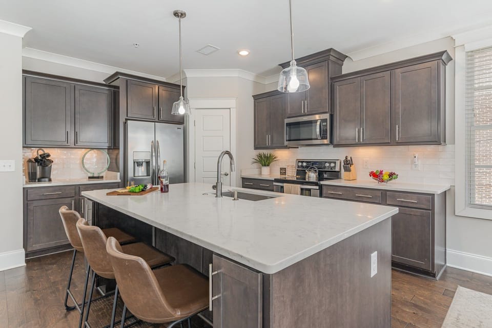 Fully equipped kitchen stocked with all culinary essentials, stainless steel appliances and an island offering bar seating for 3 guests.