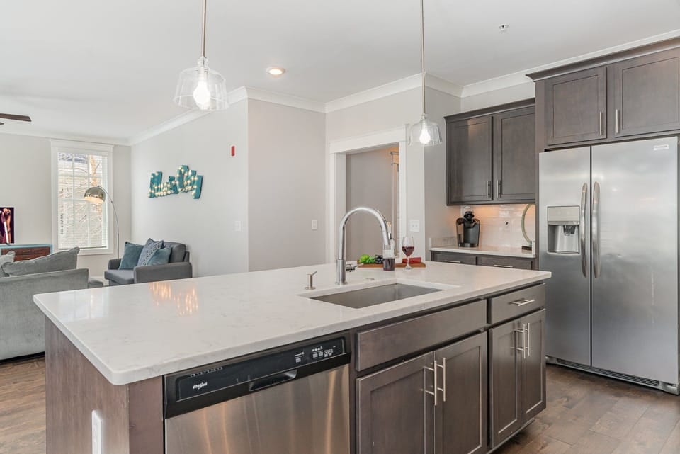 Fully equipped kitchen stocked with all culinary essentials, stainless steel appliances and an island offering bar seating for 3 guests.