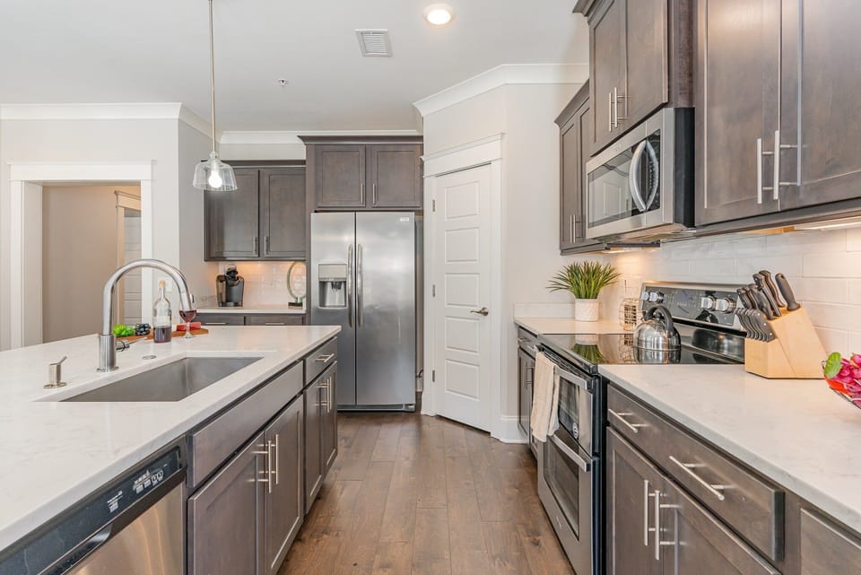 Fully equipped kitchen stocked with all culinary essentials, stainless steel appliances and an island offering bar seating for 3 guests.