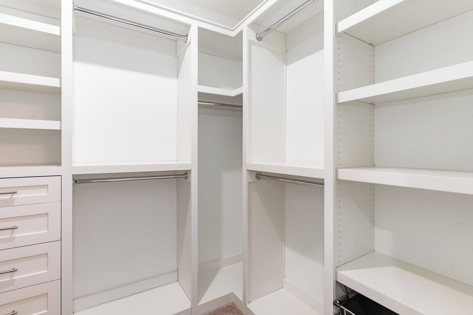 Primary Bedroom featuring a King bed with Smart TV, walk-in closet, and en-suite bathroom.