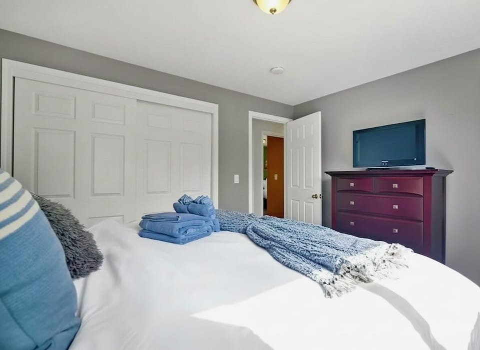 Spacious master bedroom with king bed, TV, and soft linens for ultimate comfort.