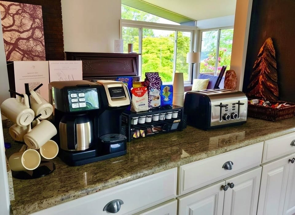 Gourmet coffee & toast station with pods, mugs, and sunny views