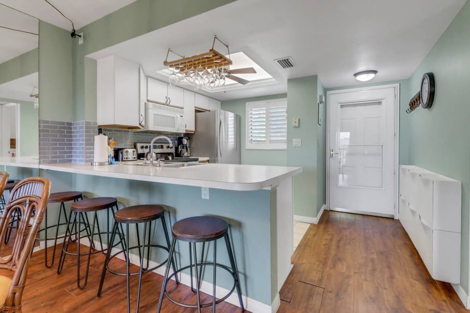 An eating bar with 4 bar stools separates the kitchen from the main living space.
