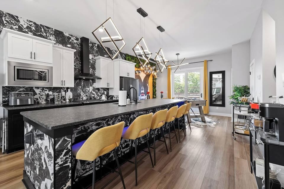 Townhouse 1: The modern kitchen is a showstopper, featuring a sleek marble-inspired island with seating for six, perfect for family breakfasts or late-night conversations. 