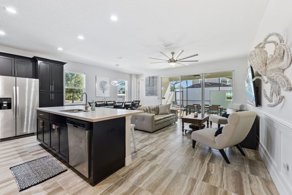 Open floor plan with kitchen, dining room and living room looking out to private heated pool.