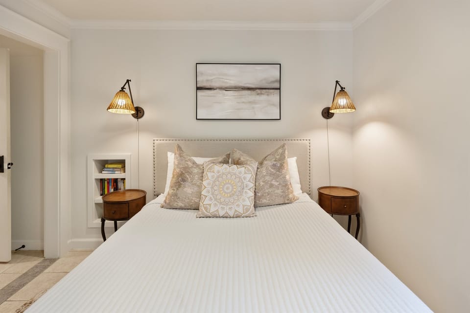 Drift off in your beautifully appointed bedroom, where soft linens and warm sconce lighting create the perfect sanctuary for rest.