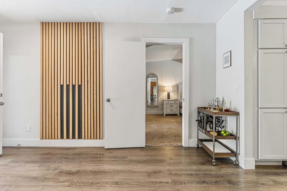 Kick off your stay with a drink! Our stylish bar cart and modern wood-slat feature wall create the perfect backdrop for your vacation 'cheers.