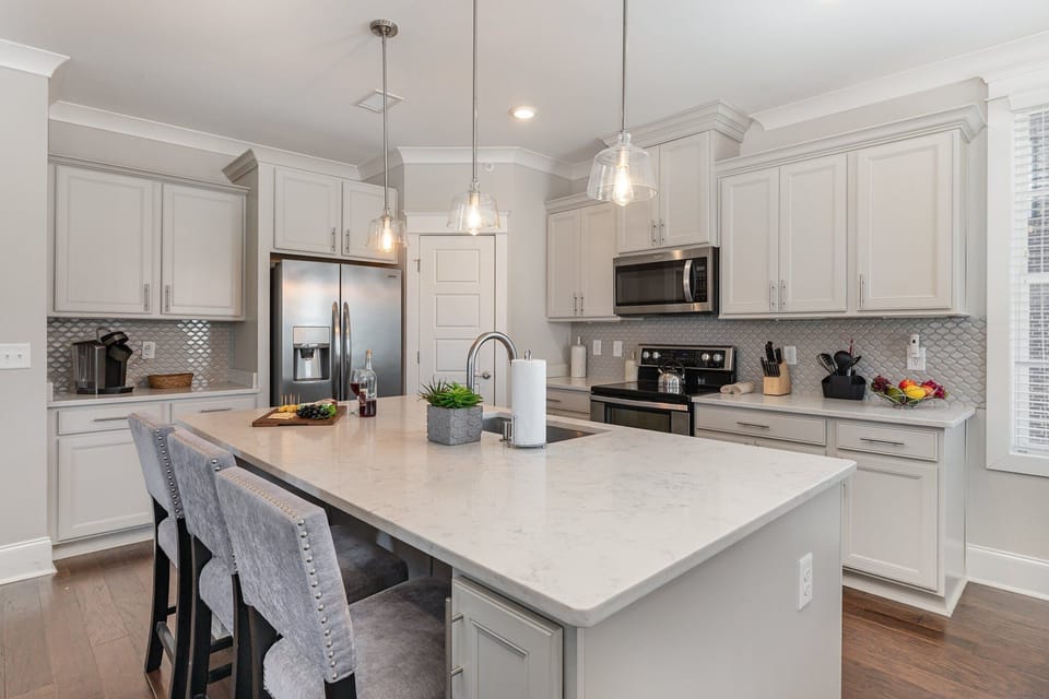 Fully equipped kitchen stocked with all culinary essentials, stainless steel appliances and an island offering bar seating for 3 guests.