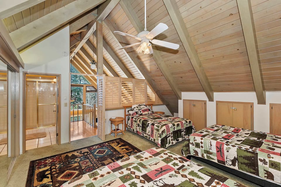 The loft bedroom includes a pair of queen beds, a full bed, & an ensuite bath