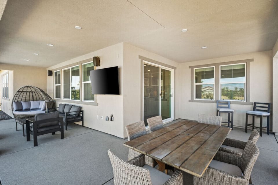 Covered patio w/ dining table, lounge seating & TV for laid-back evenings