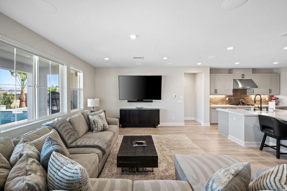 Bright living area w/ cozy seating, large windows & open flow to the kitchen