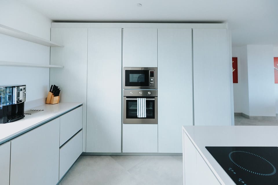 Your fully-equipped kitchen features sleek modern cabinetry, built-in appliances including oven and microwave, and an induction cooktop—everything you need to create delicious home-cooked meals during your stay.