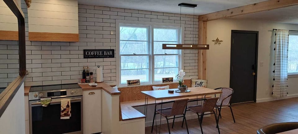 Bright farmhouse kitchen with dining table and cozy coffee bar in Villa Bella