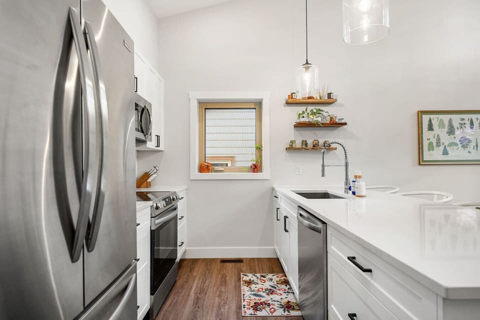 Full kitchen with island seating, a blender, drip coffee machine, ground coffee, tea & sugar.