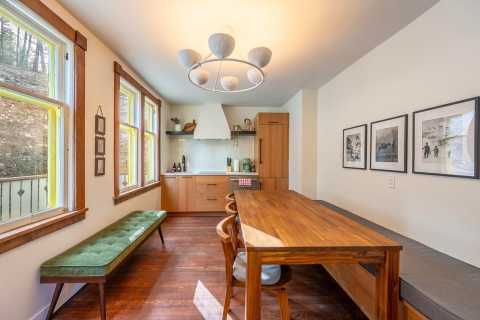 Gather around a spacious dining table with natural wood finishes and natural light streaming in.
