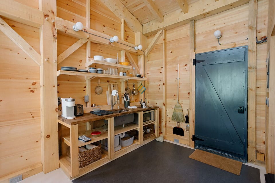 Kitchenette has utensils, dishware, serving bowls, pots and pans. 