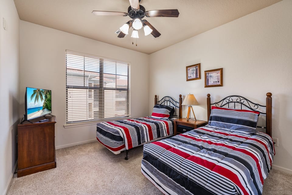 Bedroom 3 showing 2 twin beds, tv, and ceiling fan.