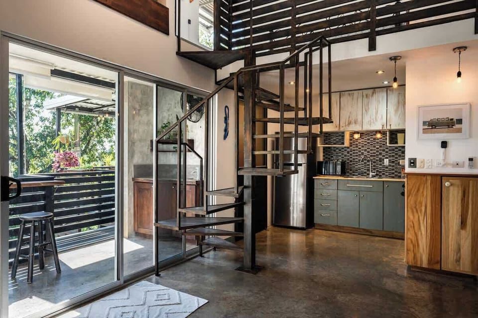 View Of Spiral Staircase to Third Floor Mezzanine, Kitchen/Bathroom Area on the Right and Access to Outside Terrace on The Left