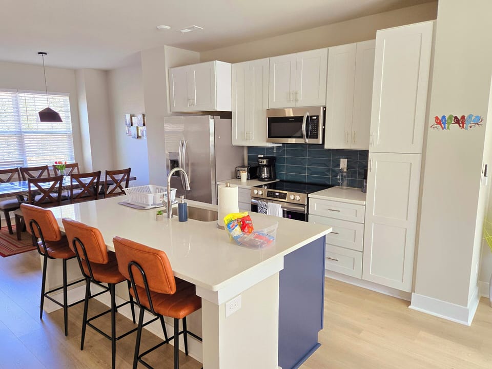 The kitchen has a full fridge, microwave, coffee maker, stove, toaster, blender