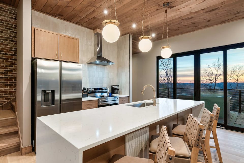 The expansive island invites lively conversations, while the warm wooden ceiling adds a touch of rustic charm. 
