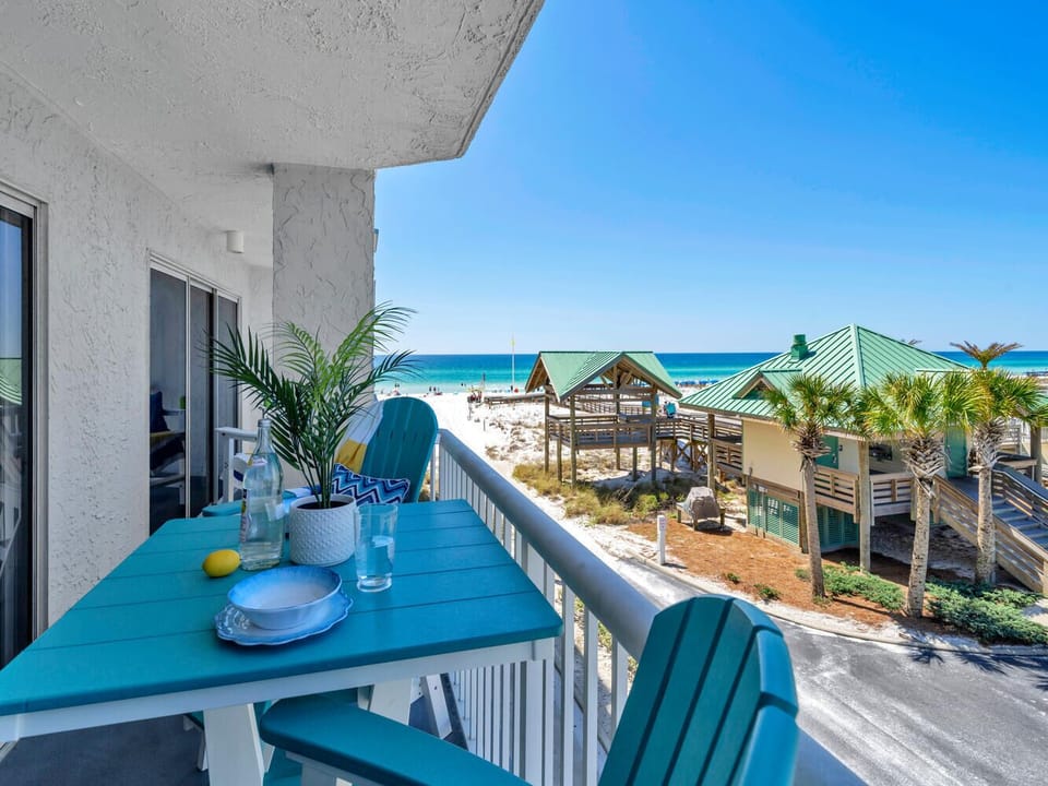 Sip your morning coffee at this charming balcony table while gazing at pristine white sands and turquoise waters just steps away.