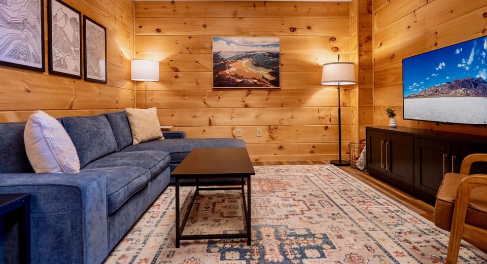 Step into the inviting warmth of the Sapphire Owl's living room. Featuring a comfortable sectional, stylish decor, and an entertainment center, it's the perfect spot to unwind and connect.