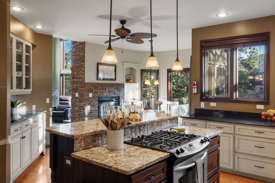 Large fully stocked kitchen with Gas range stove, two ovens and center island.
