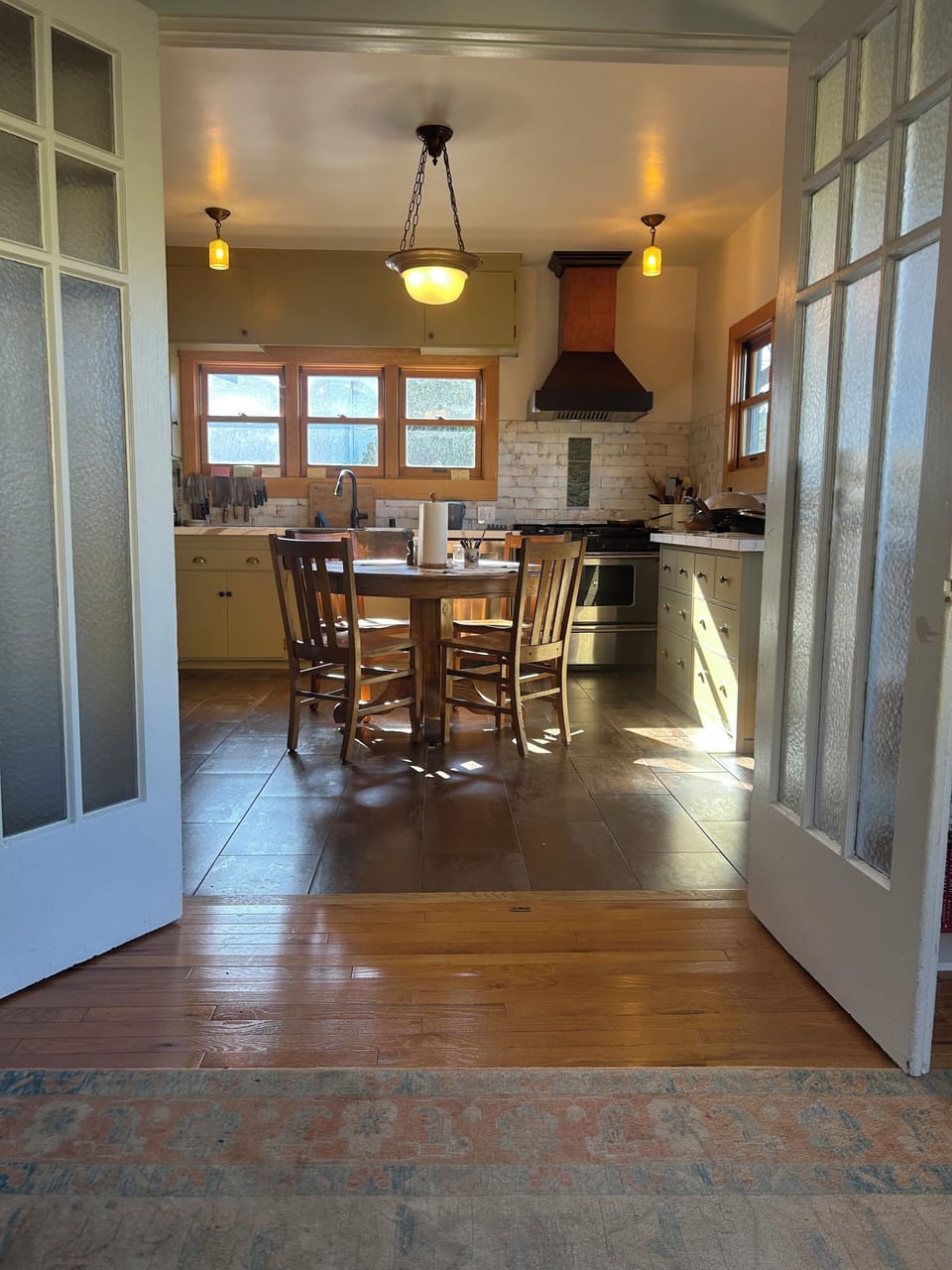 View of kitchen from bedroom on bottom floor,  separated by French doors