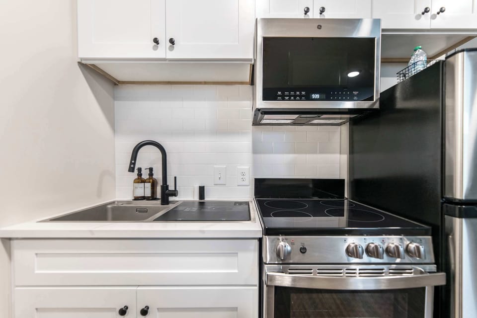 The kitchen includes a 2-in-1 sink dishwasher, as well as a stove/oven, microwave, and refrigerator.